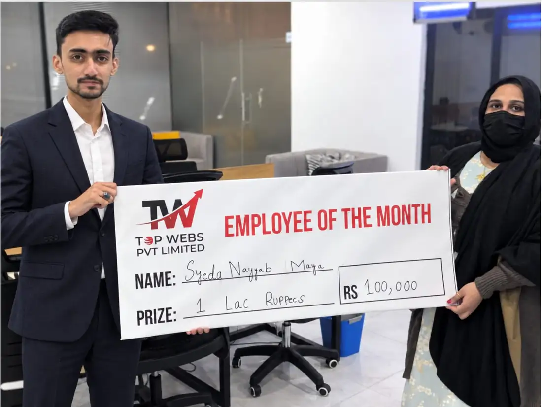 A Topwebs team member receiving the Employee of the Month award at the office