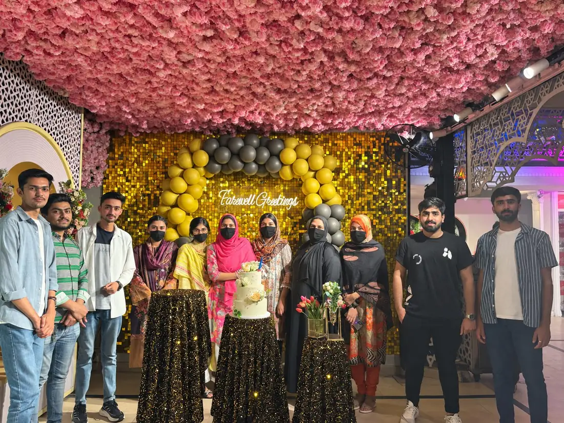 The Topwebs team gathered under a Farewell Greetings sign with a cake and balloons
